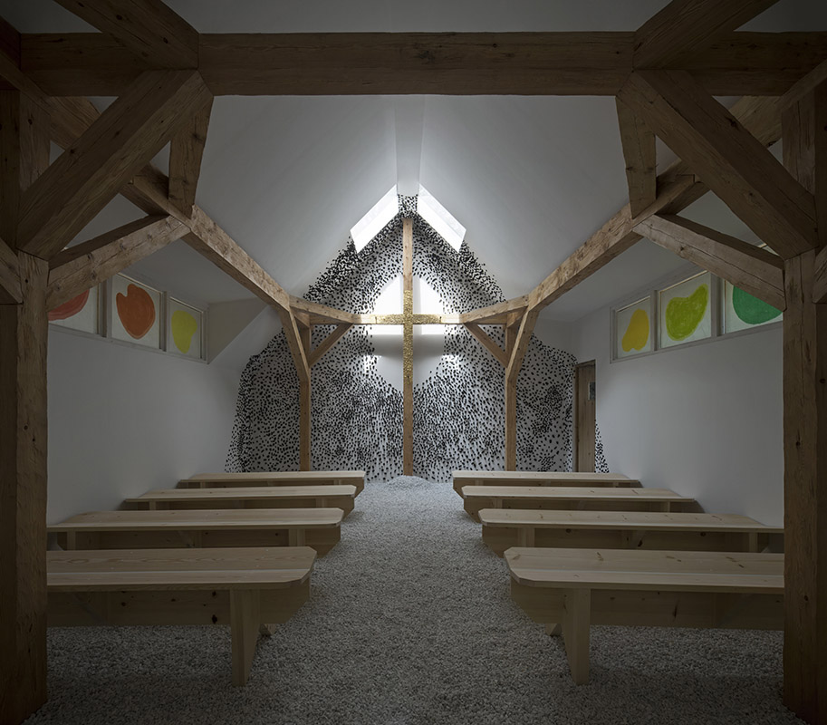 Cruz de madera dentro de la capilla de la Bienal de Venecia cubierta de hojas de oro