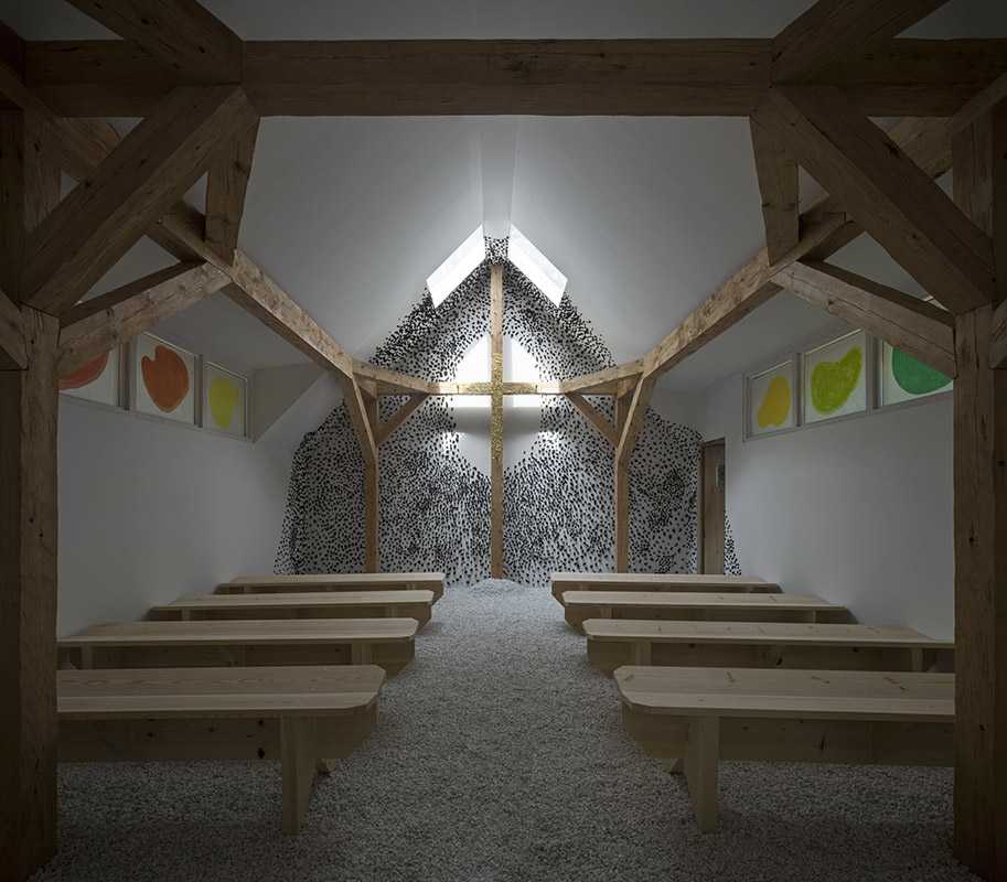 Cruz de madera dentro de la capilla de la Bienal de Venecia cubierta de hojas de oro