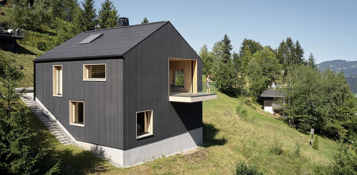 Maison de vacances en bois massif. La forme et la couleur interagissent avec les bâtiments environnants